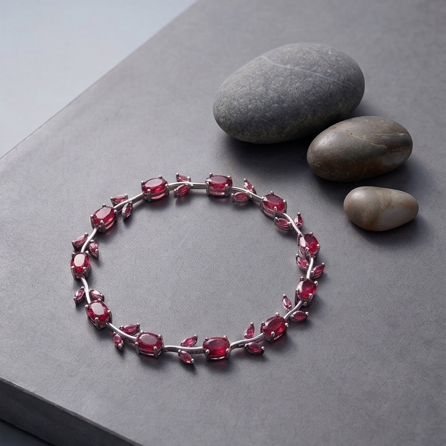 Bracelet with red gemstones on a gray surface with stones
