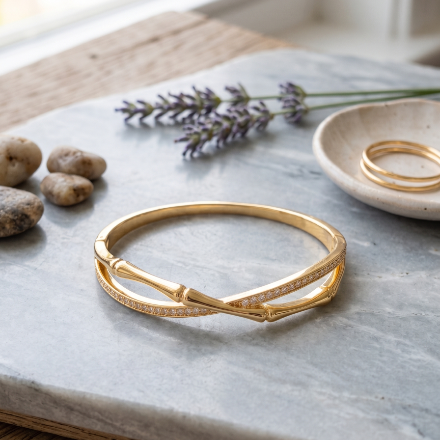 Gold bracelet on a marble surface with lavender and stones