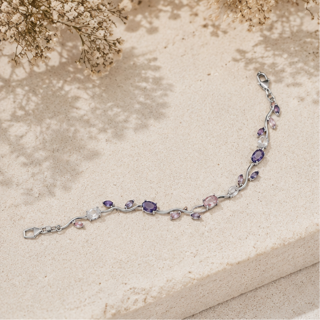 Silver bracelet with purple gemstones on a textured beige surface