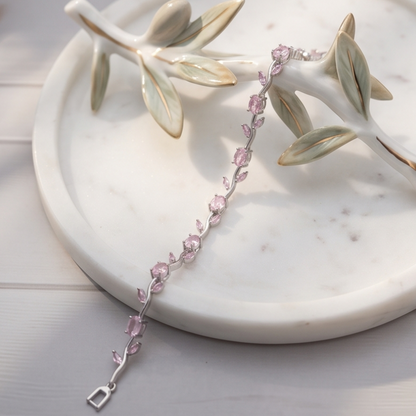Delicate pink bracelet with silver clasp on a marble surface