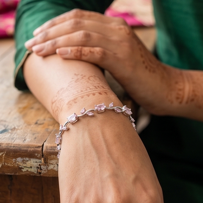 Close-up of a wrist wearing a pink bracelet with a blurred background